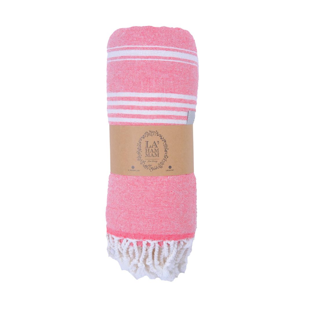 Pink towel with white stripes and fringes, branded 'La Ham', on a white background